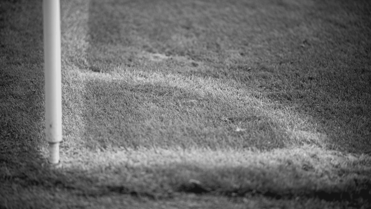 Der Rasen um eine Eckfahne, schwarz-weiß.